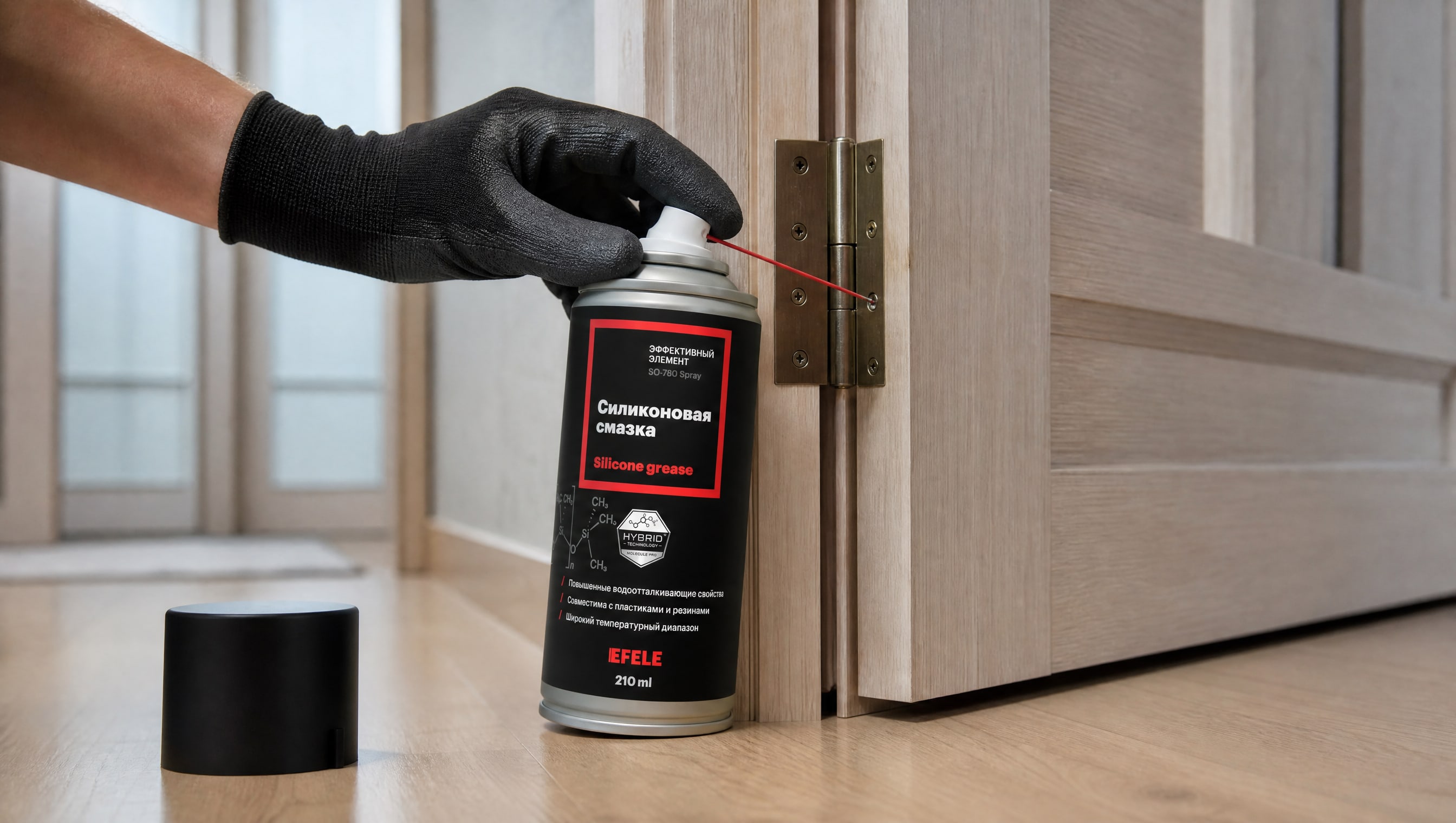 Рука в перчатке наносит EFELE SO-780 Spray (силиконовую) на дверные петли.