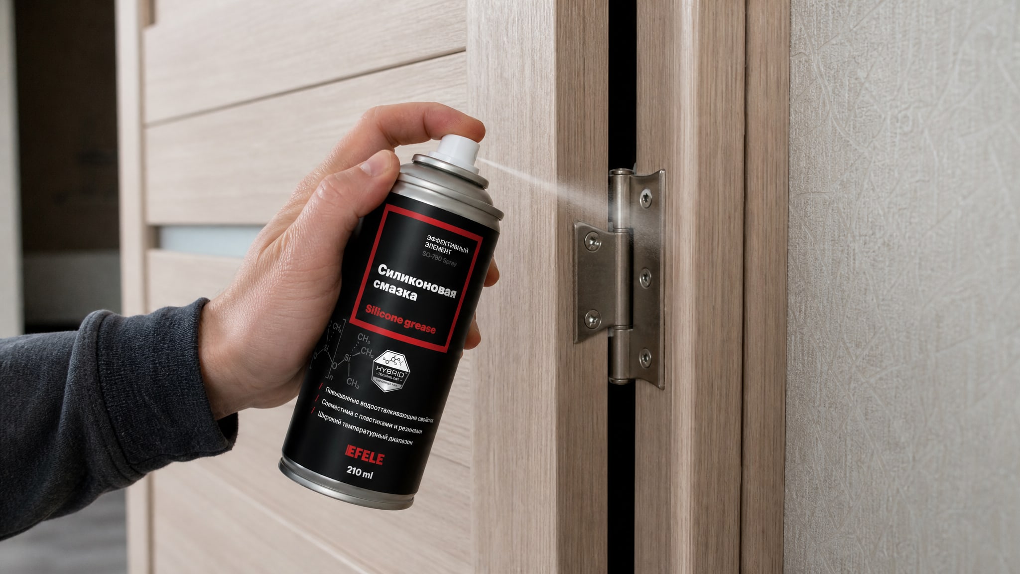 Рука в перчатке наносит EFELE SO-780 Spray (силиконовую) смазку на петли.