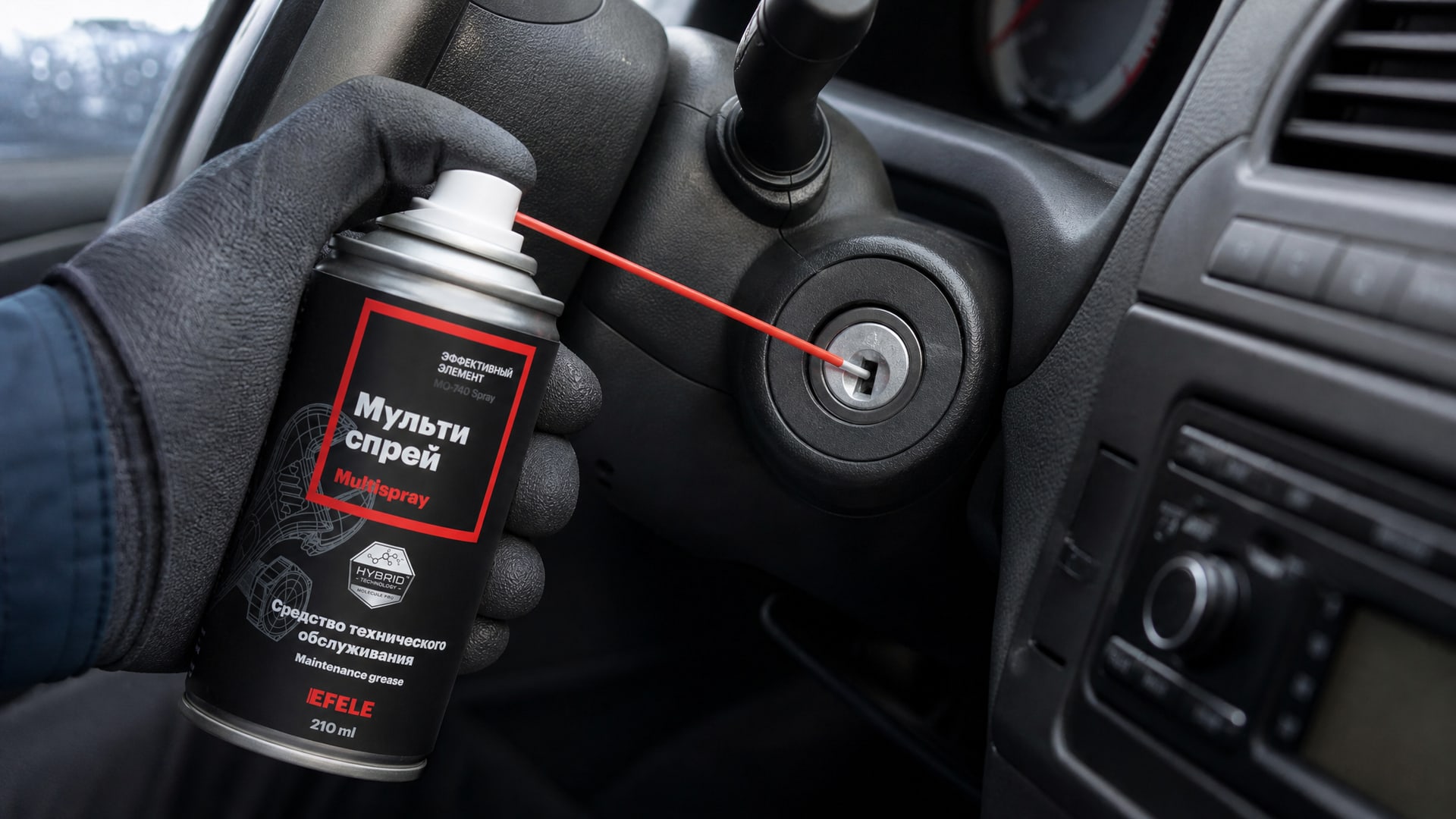 Рука наносит мультиспрей EFELE MO-740 Spray, чтобы смазать замок зажигания.