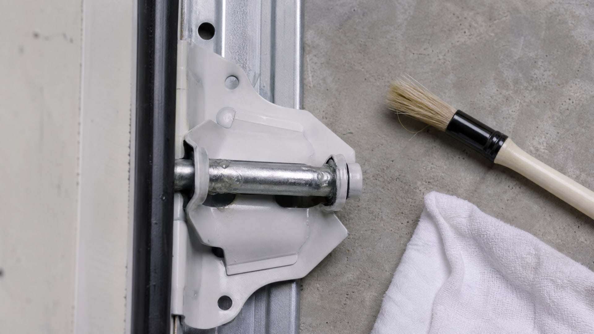 Нанесение смазки WD40 на шарнирный палец гаражной петли.
