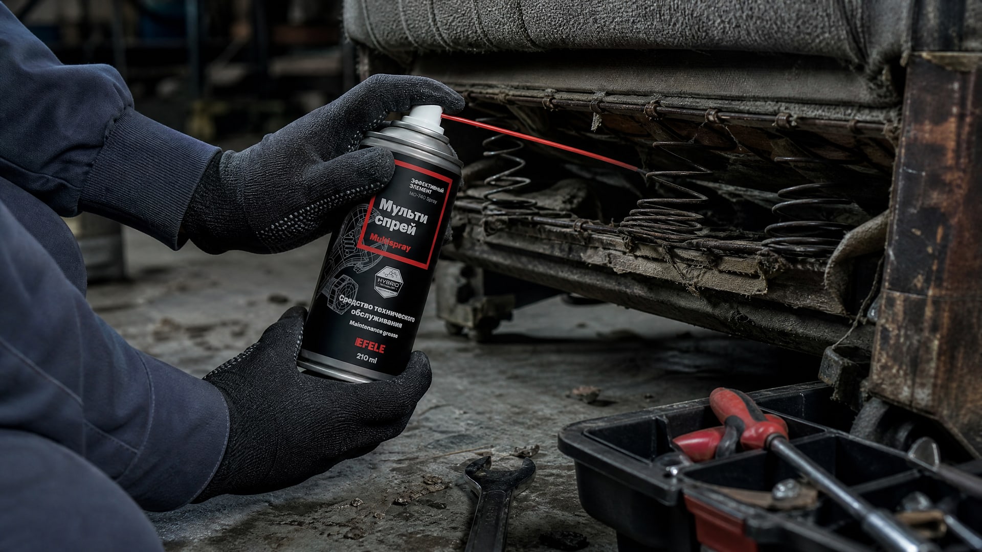 Рука в перчатке наносит мультиспрей EFELE MO-740 Spray, устраняя скрип дивана.