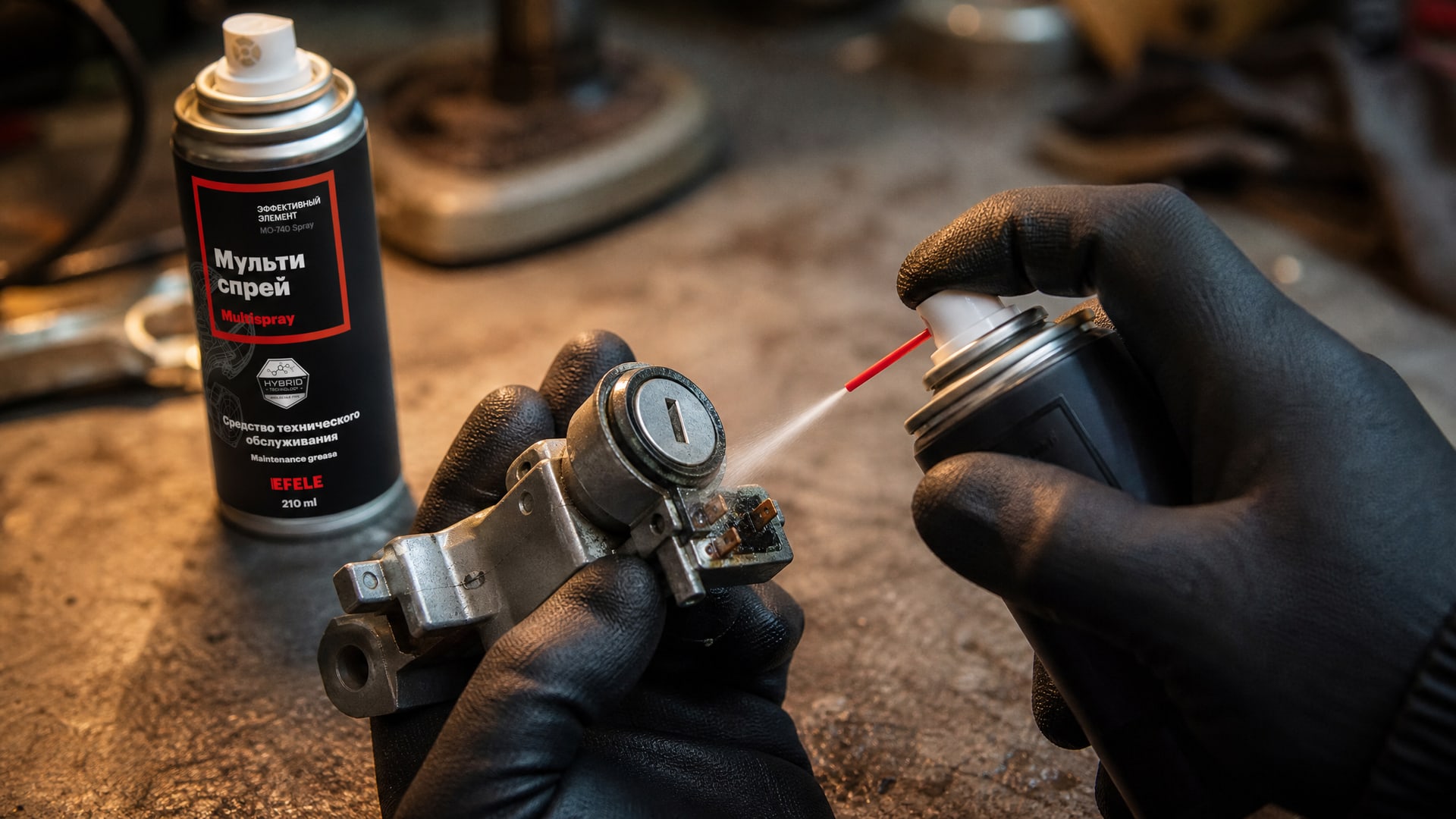 Рука наносит EFELE MO-740 Spray, чтобы смазать замок зажигания автомобиля.