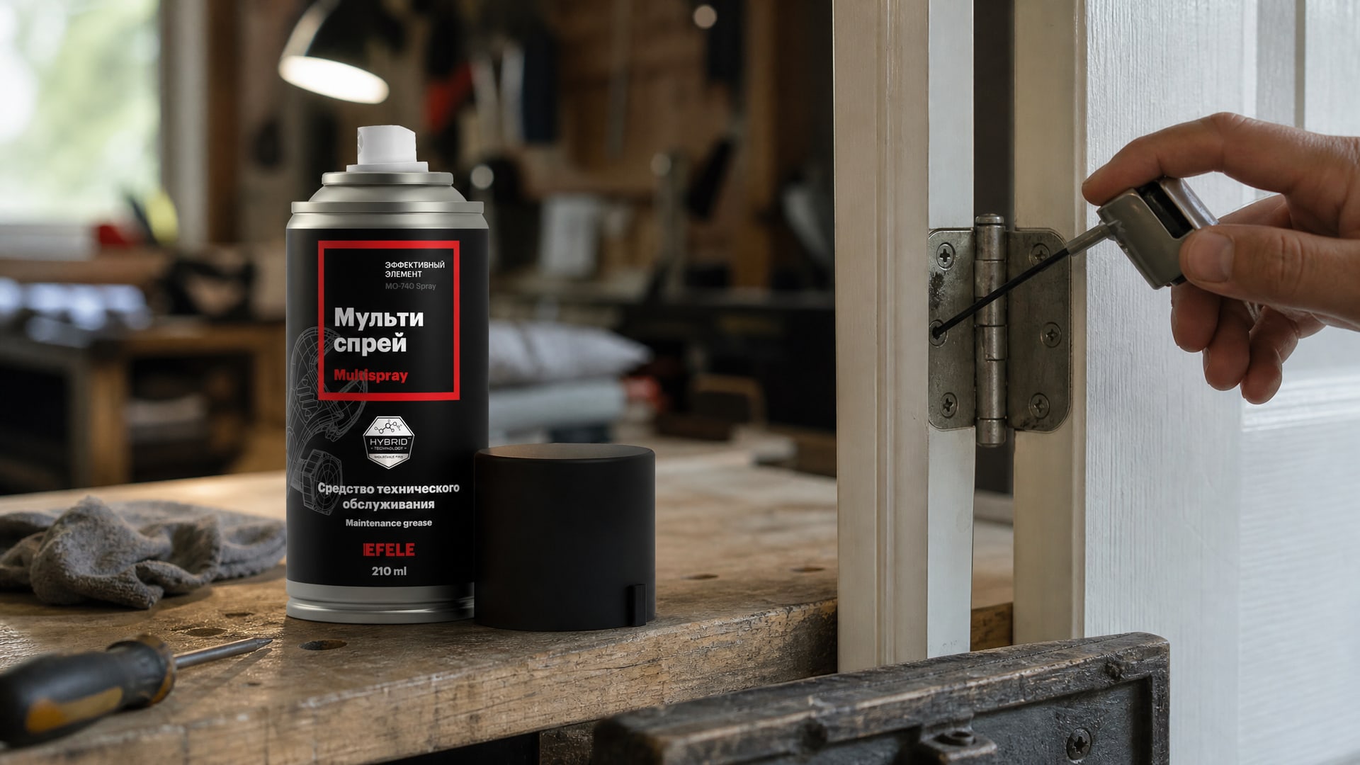Рука в перчатке наносит мультиспрей EFELE MO-740 Spray, чтобы смазать дверные петли.