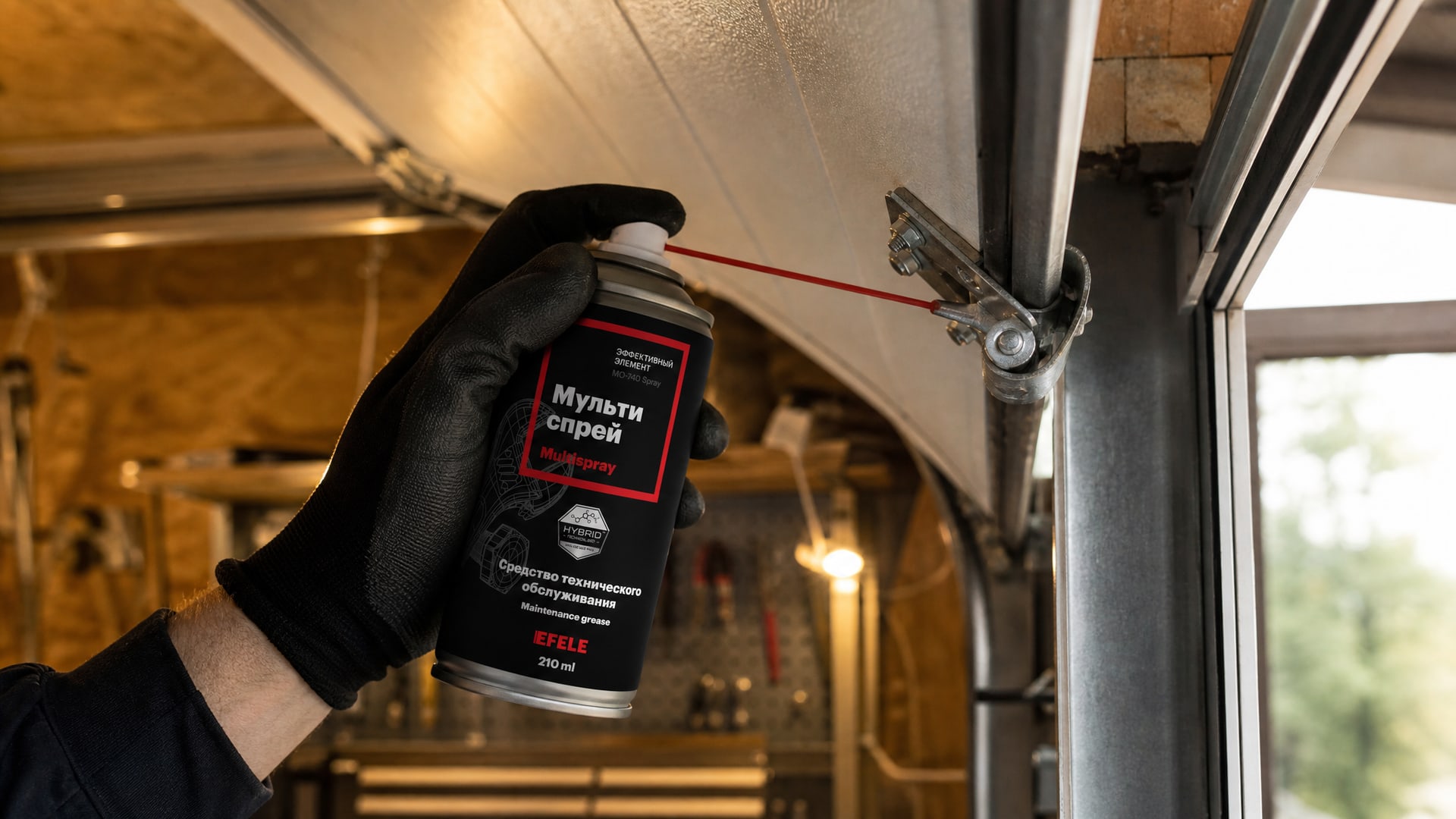 Рука в перчатке наносит EFELE MO-740 Spray, чтобы смазать гаражные ворота.